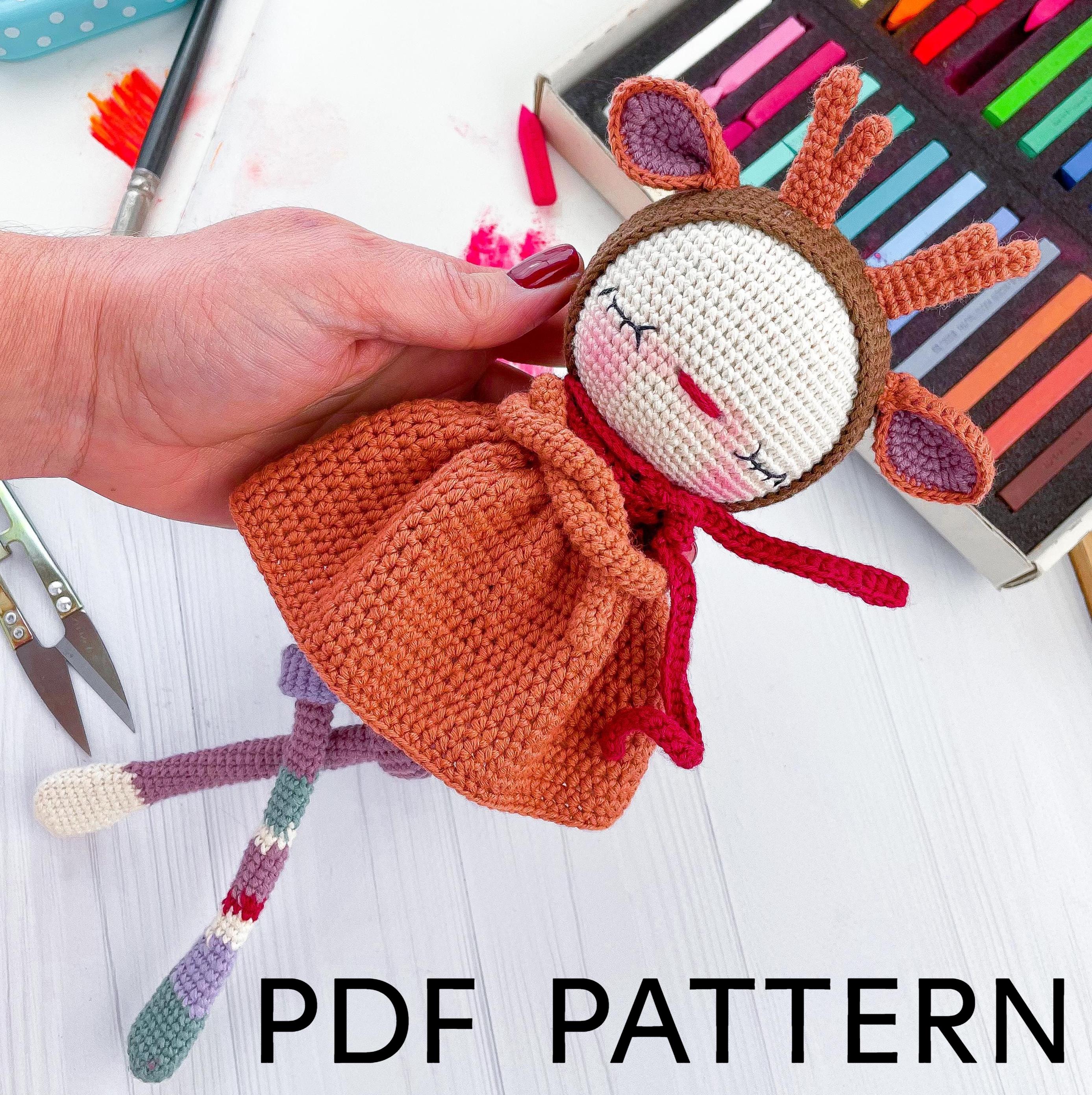 a crocheted doll being held by a hand